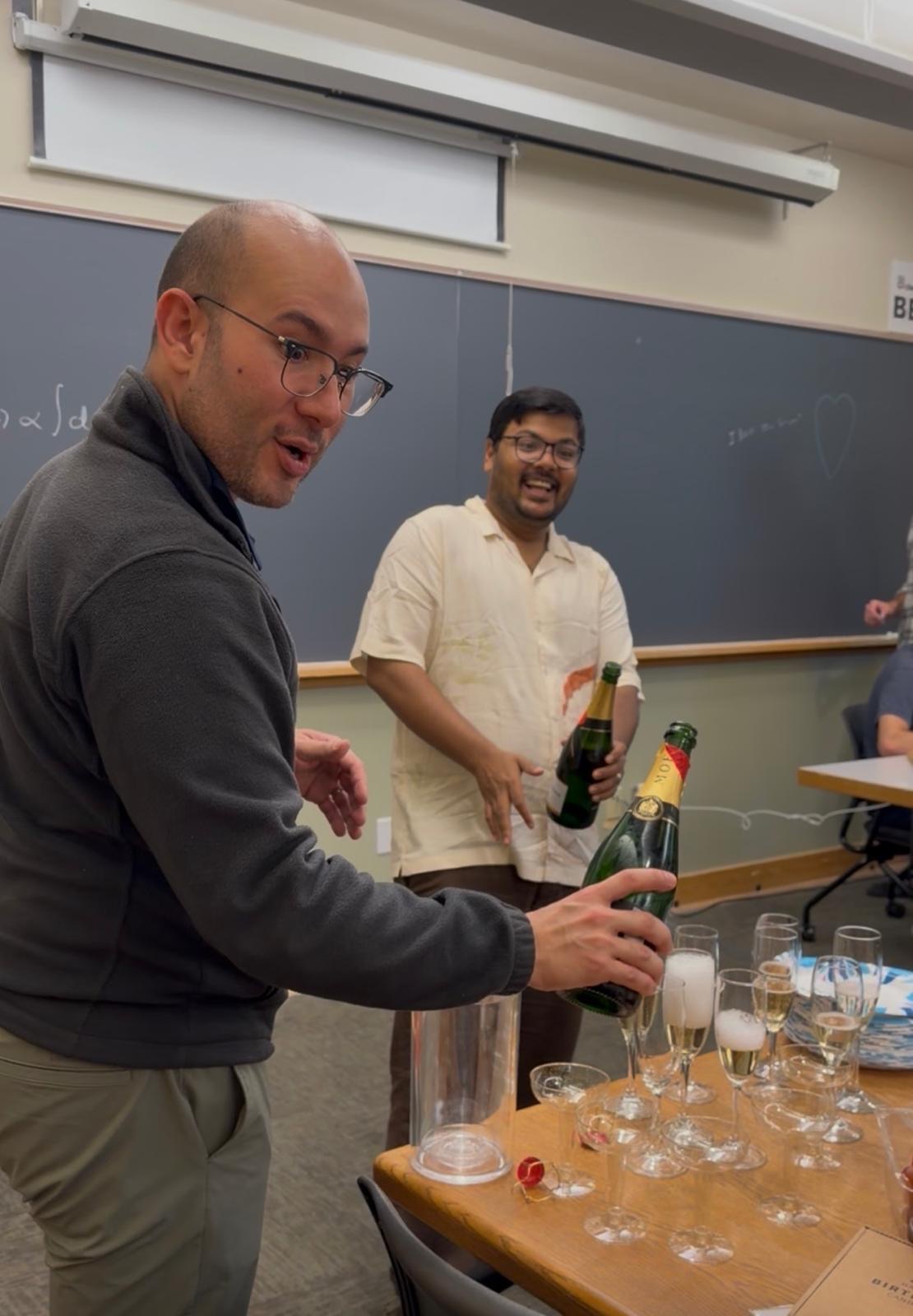 Andrés pouring champagne at Srijan's defense celebration