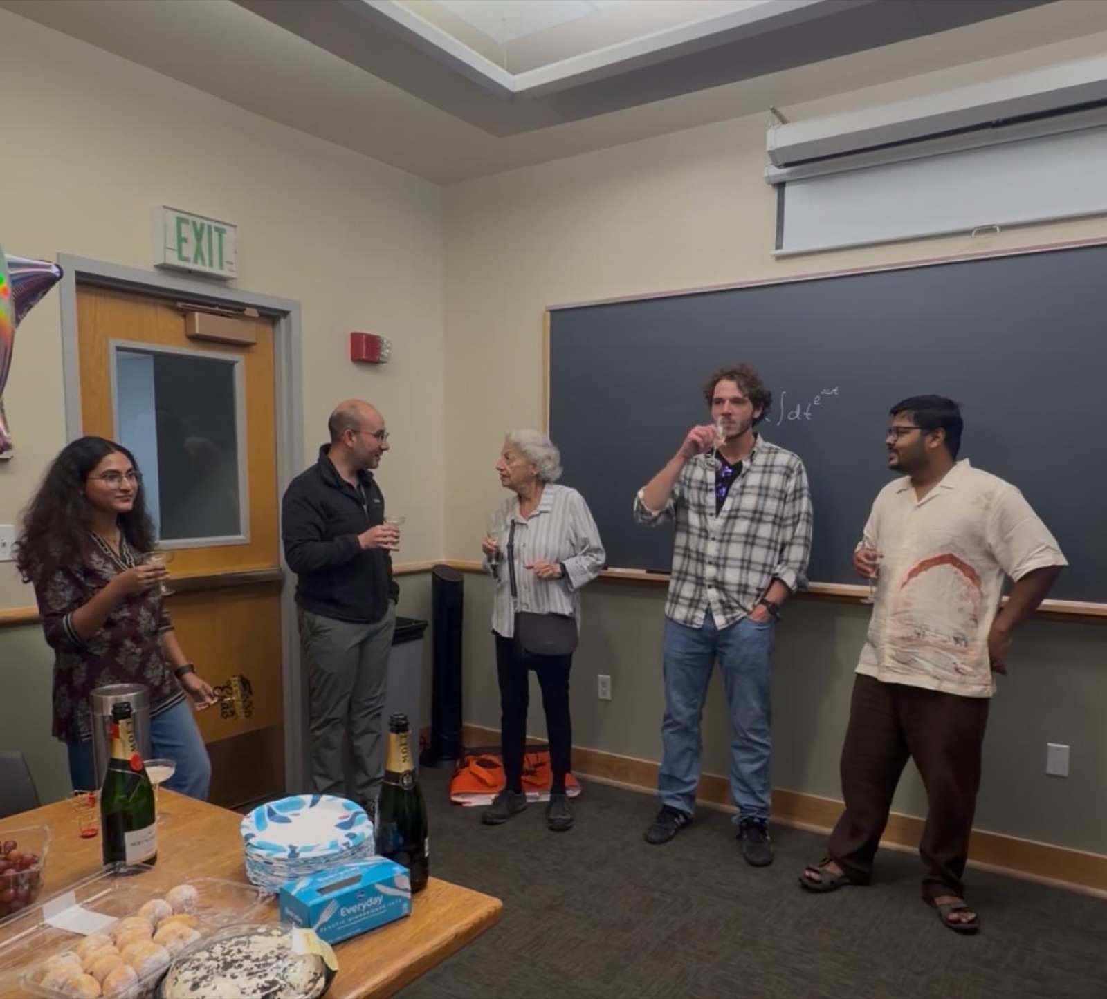 Group members toasting Srijan after his defense